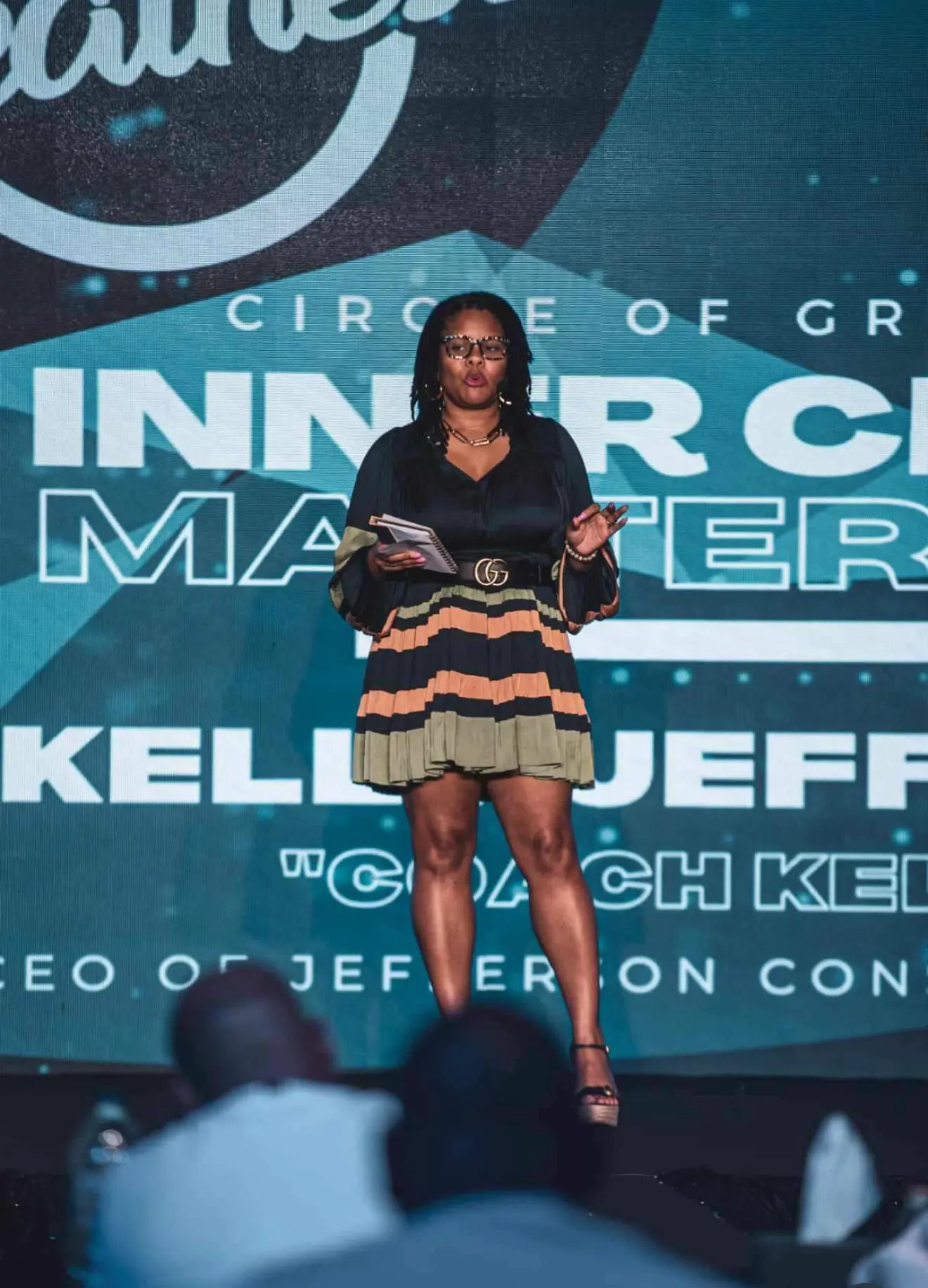 Coach Kelly J speaking on stage
